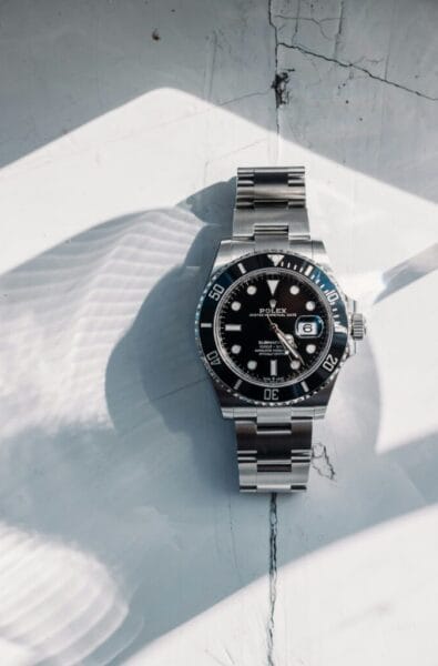 Rolex Submariner stainless steel watch on textured white surface