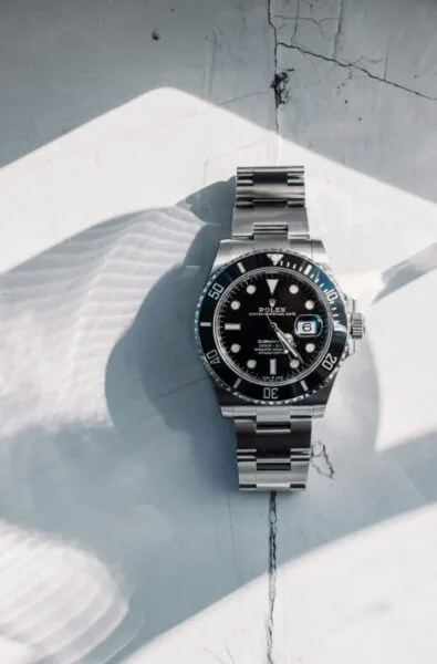 Rolex Submariner stainless steel watch on textured white surface
