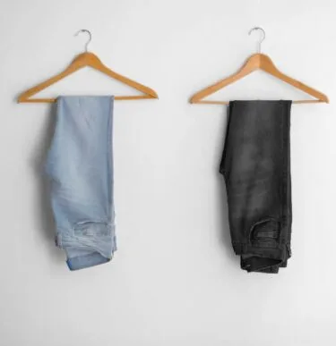 Light wash and dark wash jeans folded on hangers – guys spring outfit essentials