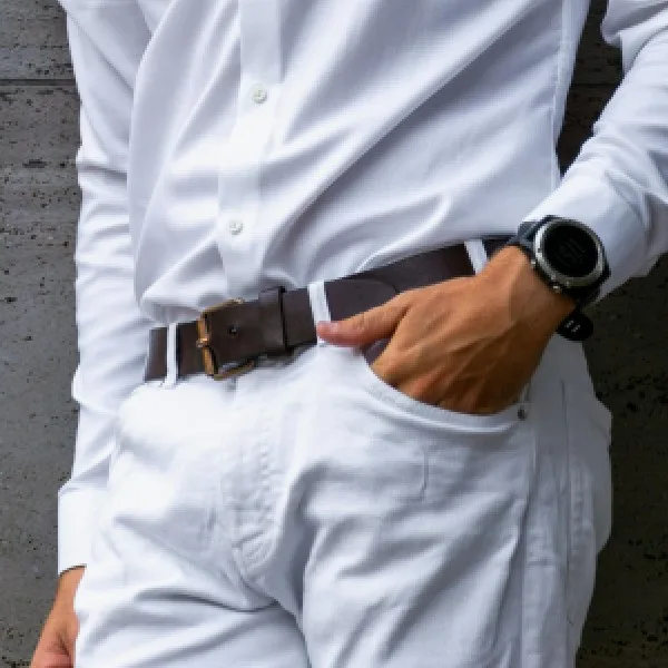 Close-up of a man wearing a white shirt and white pants with brown belt – spring outfit for men
