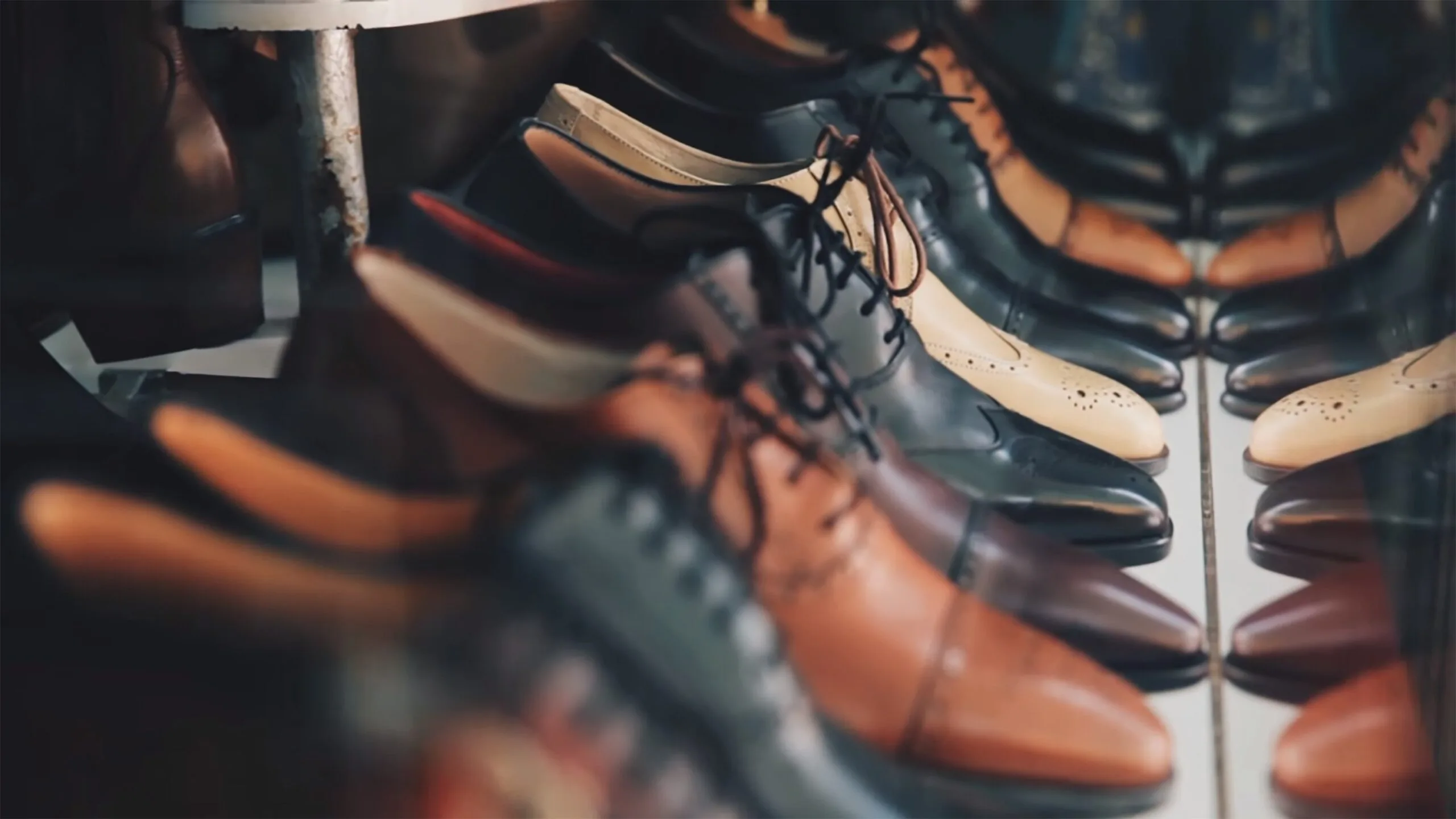 Row of men's leather dress shoes in various colors and styles – smart casual footwear options