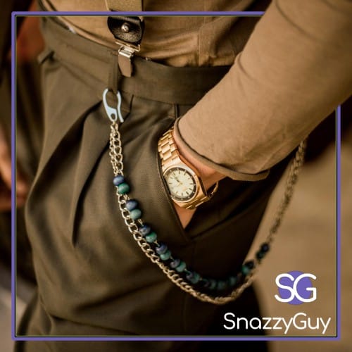 Close-up of a smart casual outfit with pleated trousers, gold watch, suspenders, and chain accessory
