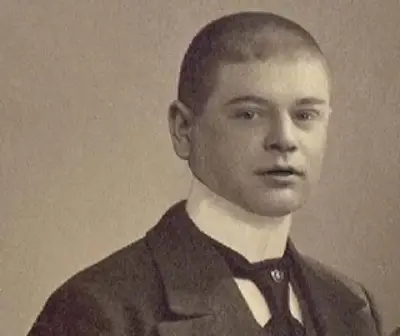Men's accessories - Tall collars Young man in a formal suit with high collar and cravat, highlighting classic men's accessories.