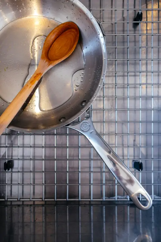 Stainless steel skillet with a wooden spoon resting inside, showing another strong option for the Best Pan for Steak.
