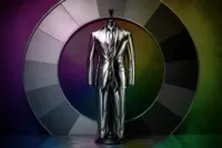 Metallic silver suit displayed on a mannequin in front of a circular monochrome color wheel.