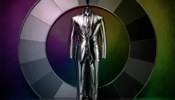 Metallic silver suit displayed on a mannequin in front of a circular monochrome color wheel.