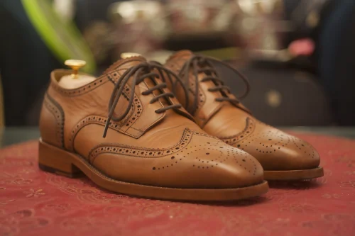 Brown leather brogue shoes with wingtip detailing styled as Dark Academia Accessories.