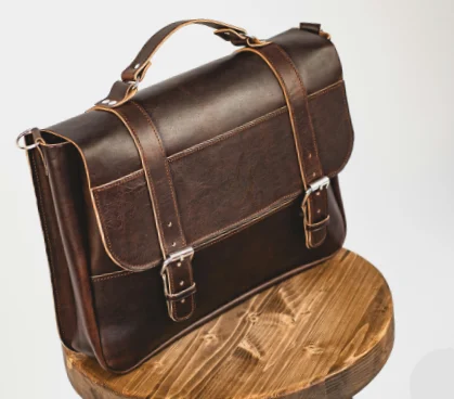 Dark brown leather messenger bag with buckle straps styled as Dark Academia Accessories.
