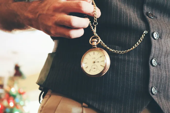Gold pocket watch with chain worn as one of several vintage Dark Academia Accessories.