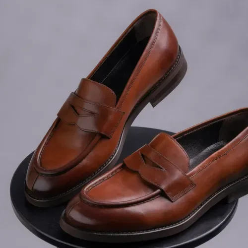 Brown penny loafers shown among classic types of men's shoes.